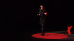 woman dressed in black in a Ted talk