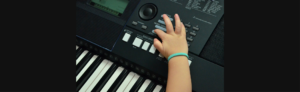 toddler's hand playing piano